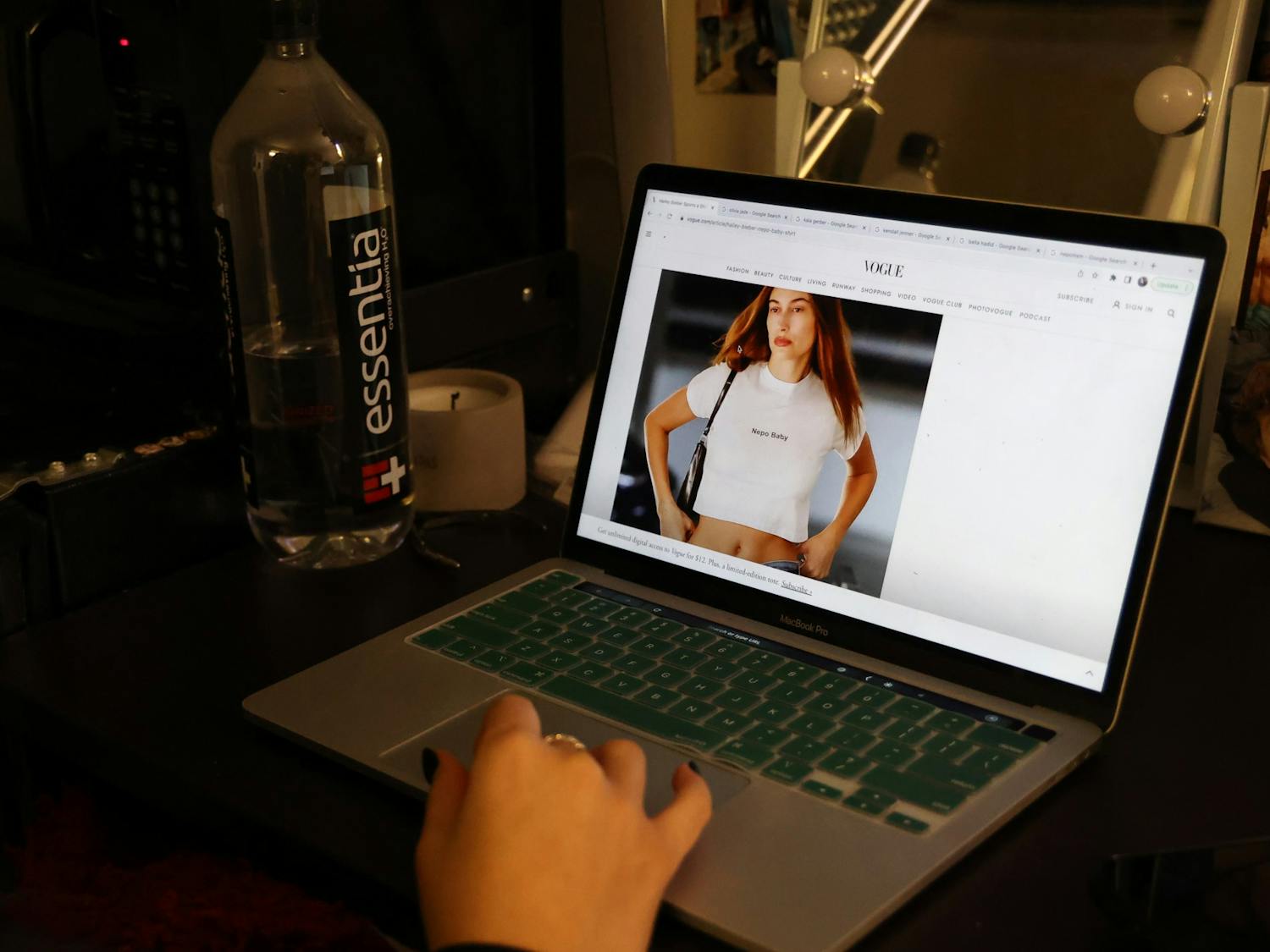 DTH Photo Illustration. A student examines Hailey Bieber's 'Nepo Baby' t-shirt on Vogue's website.