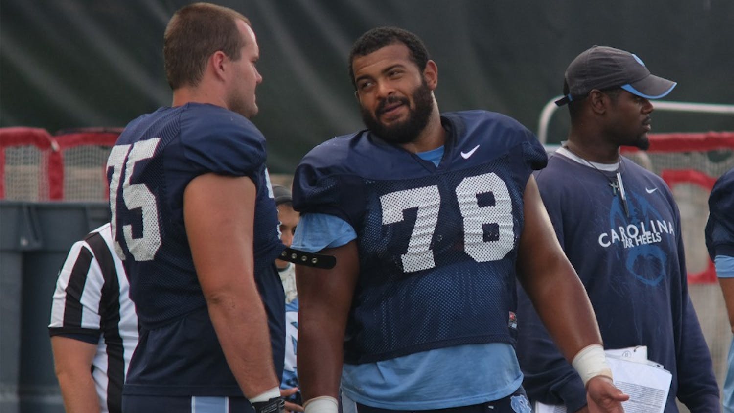 North Carolina senior offensive guard Landon Turner (78) talks with teammate Bentley Spain (75) during an afternoon practice.