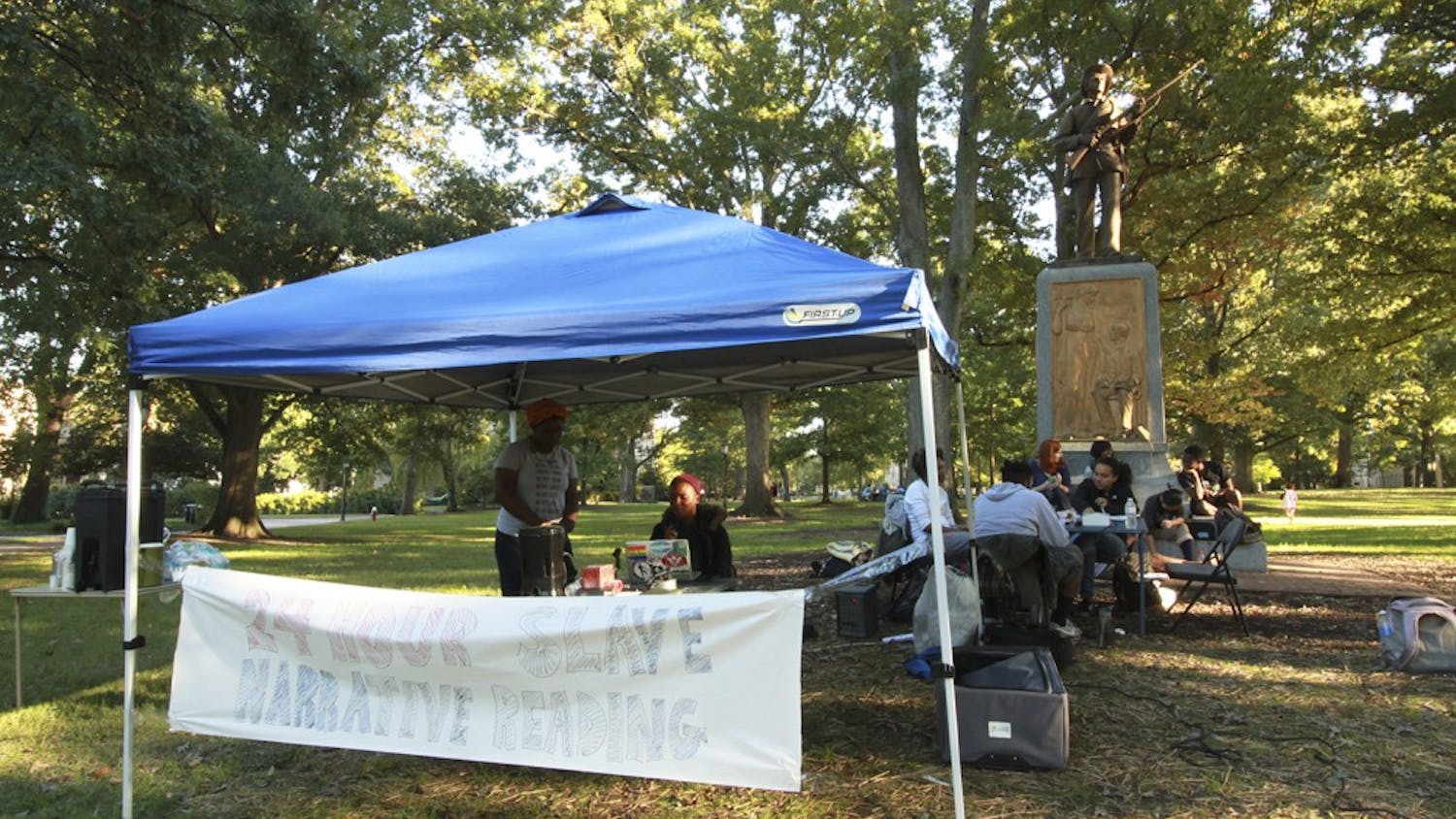 Zakyree Wallace, a senior communication studies major, reads a slave narrative in front of "Silent Sam."