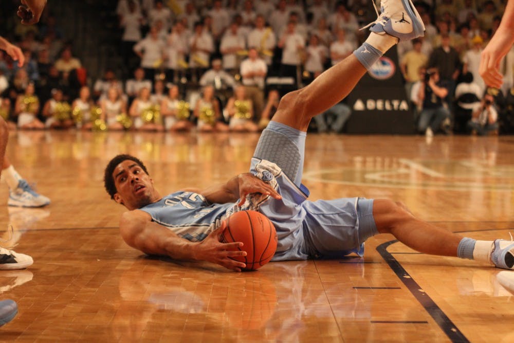 	<p>James Michael McAdoo is knocked onto the court while driving the lane.</p>