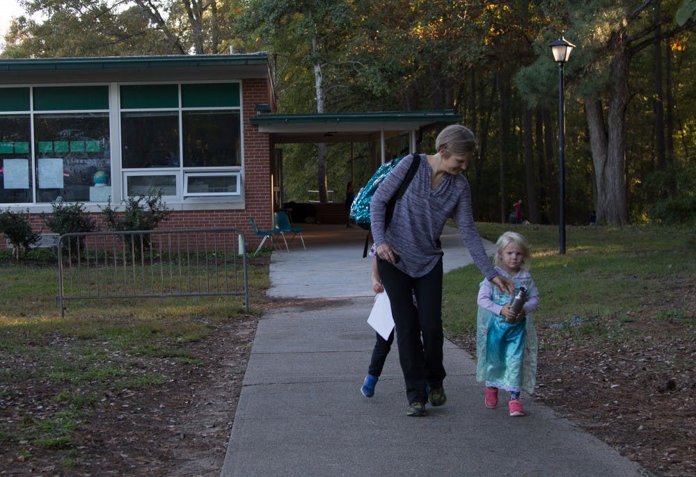 <p>Becca Wright, parent of 2 Glenwood children, Eaden and Elsa leaves with her daughter Mable after school on Tuesday Oct. 30. "I'm just glad the program isn't ending". &nbsp;Wright says as her children run circles around her.&nbsp;</p>
