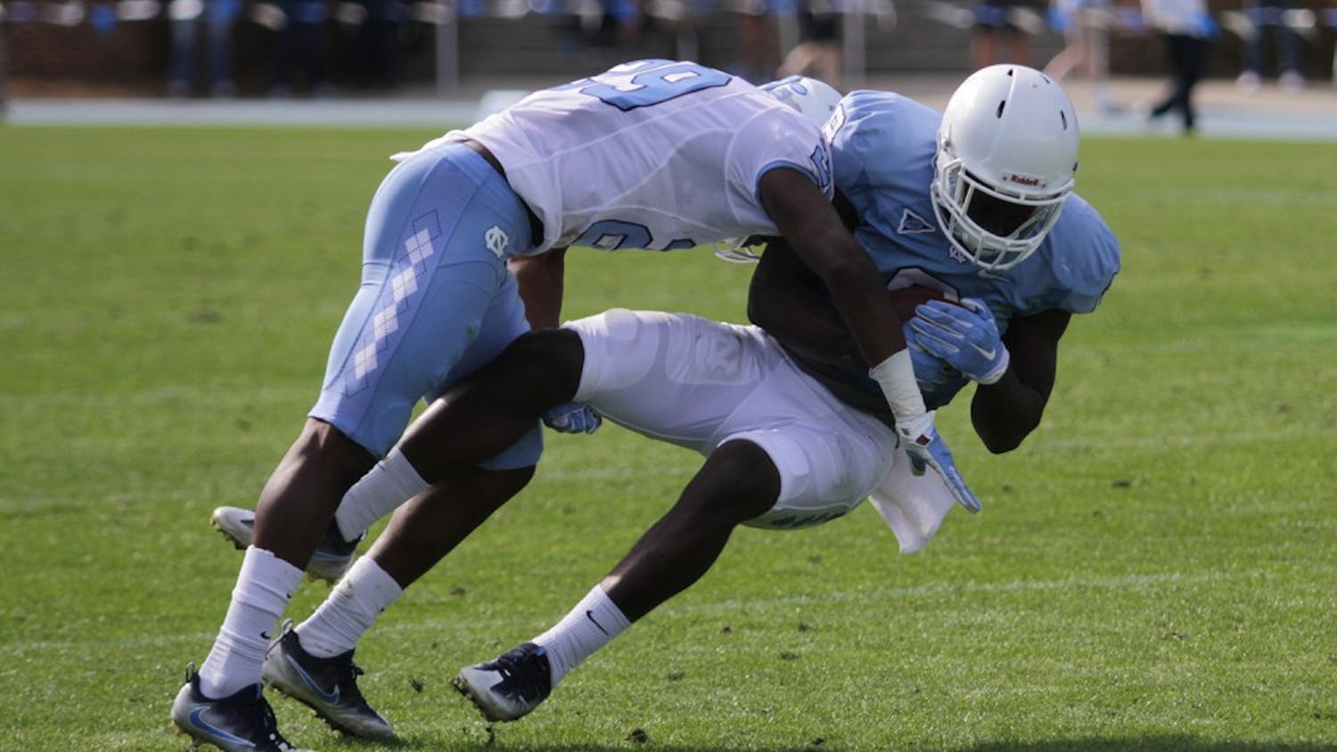 North Carolina safety J.K. Britt (29) hits wide receiver J.T. Cauthen (8) during the spring game on Saturday.
