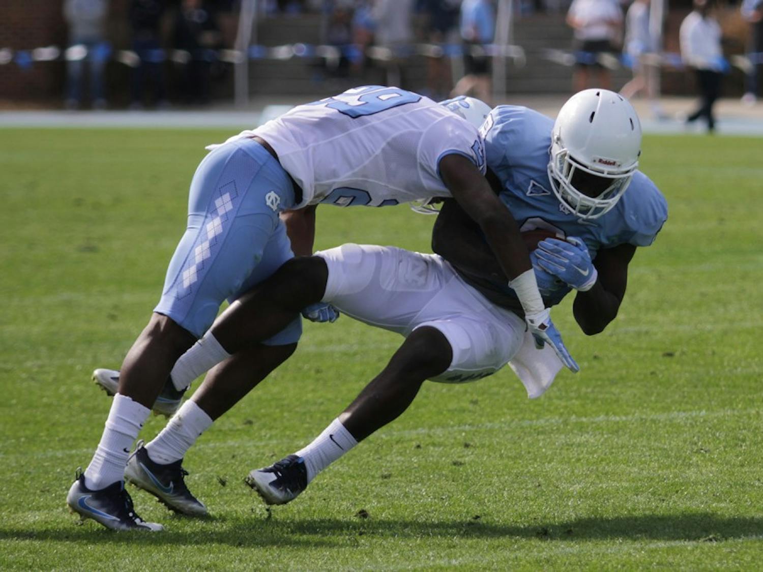 North Carolina safety J.K. Britt (29) hits wide receiver J.T. Cauthen (8) during the spring game on Saturday.