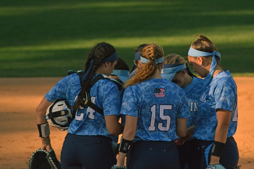The UNC softball team huddled together to discuss their plays during their game against Louisville Saturday.