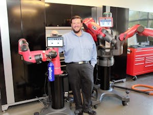 Lloyd Williams stands in front of a robot. Williams is a computer science professor at Shaw University working to diversify his field. Photo courtesy of Williams.