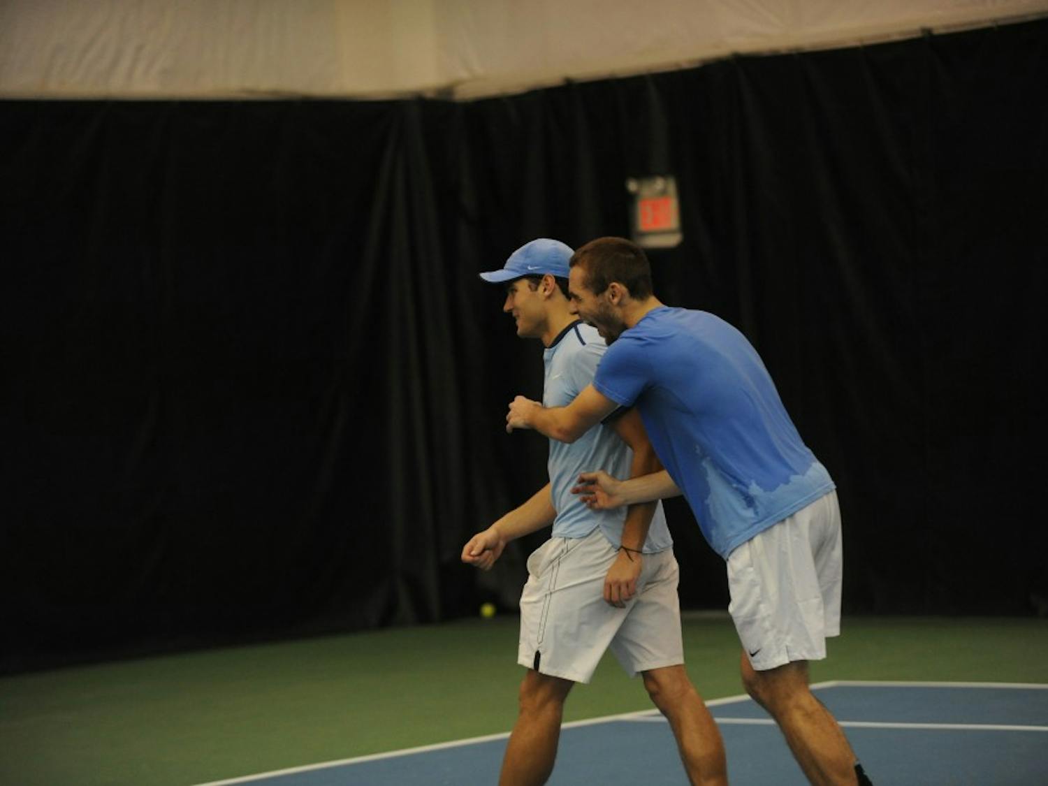 UNC tennis sophomore Benjamin Sigouin congratulates junior Ladd Harrison after competing in and winning in his first collegiate tennis match against Bucknell University on Saturday, Jan. 19. 2019. 