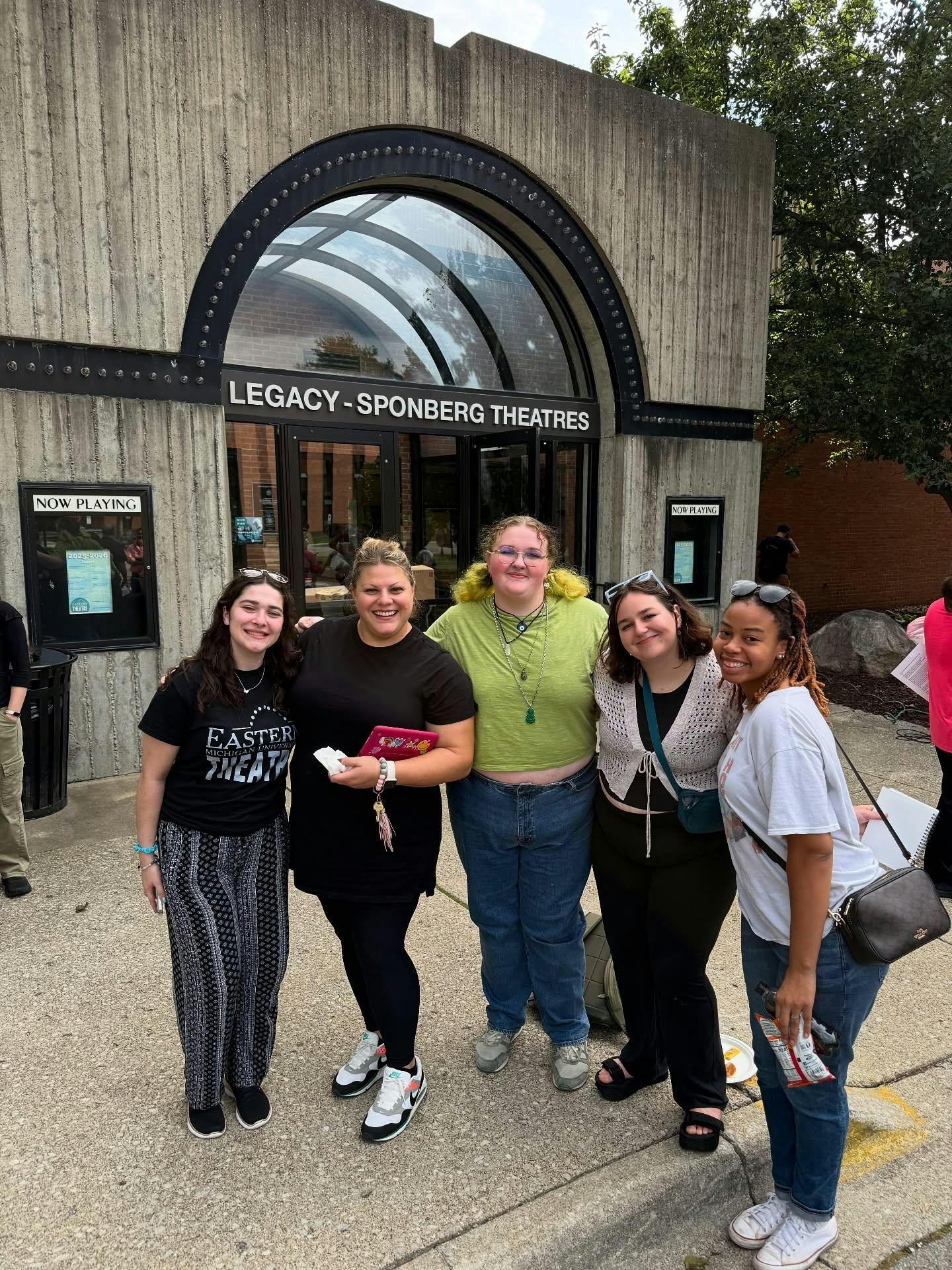Five people stand side-by-side to pose for a photo outside of Judy Sturgis Hill Building.
