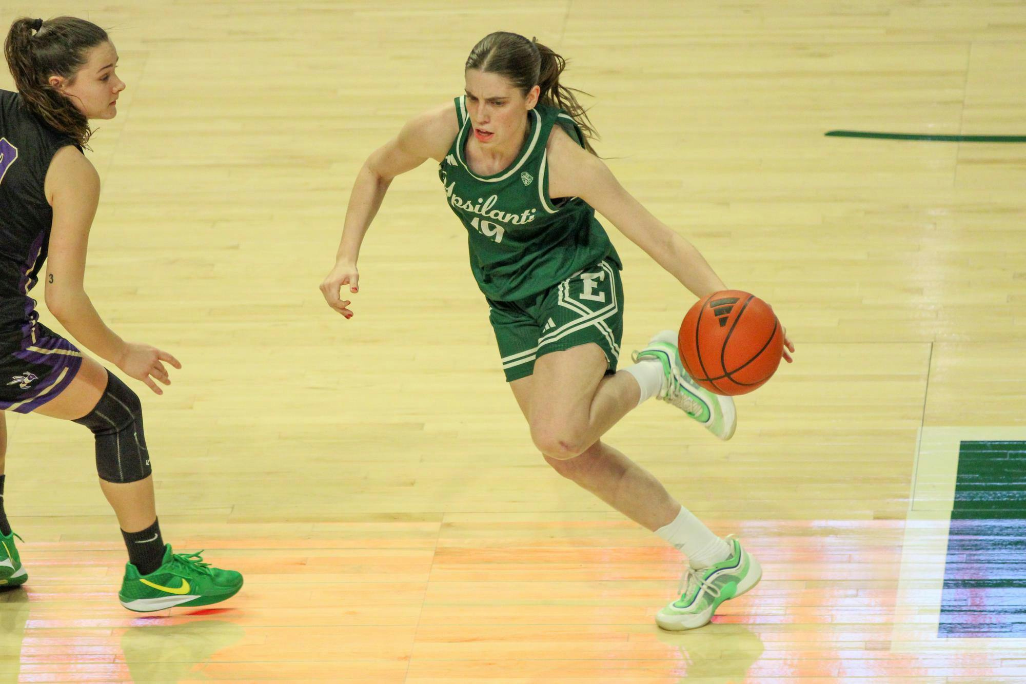#19 Paula Balada in a green Eastern Michigan University jersey, dribbling the ball.