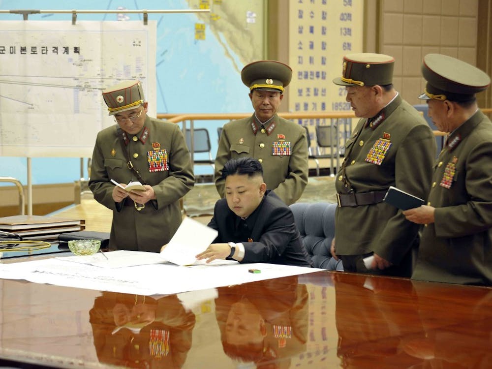 A photo provided by Korean Central News Agency (KCNA) shows North Korean leader Kim Jong Un, center, on March 29, 2013, signing an order putting rockets on standby after an urgent meeting with top generals. (KCNA/Xinhua/Zuma Press/MCT)