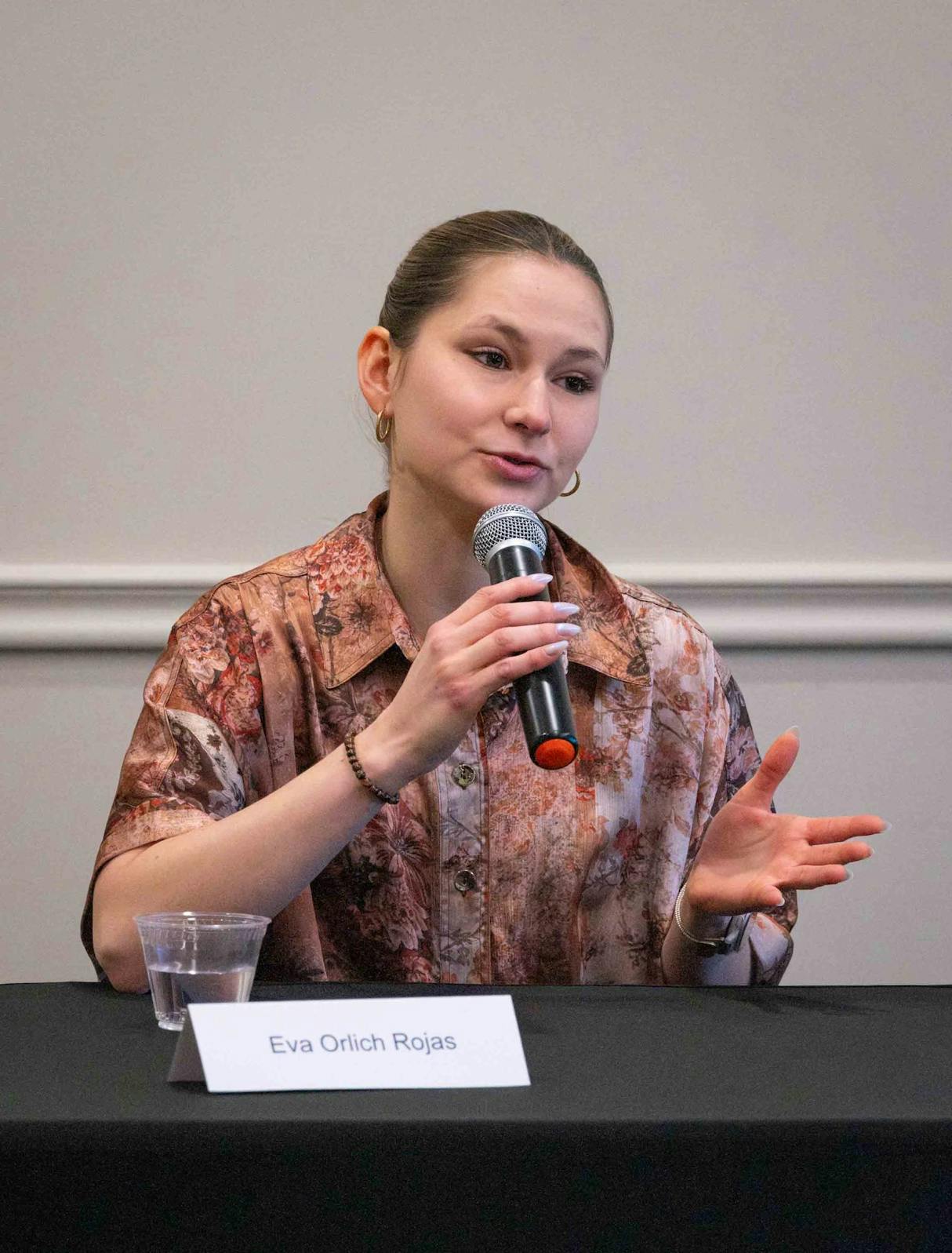 Eva Orlich Rojas speaks into the microphone.