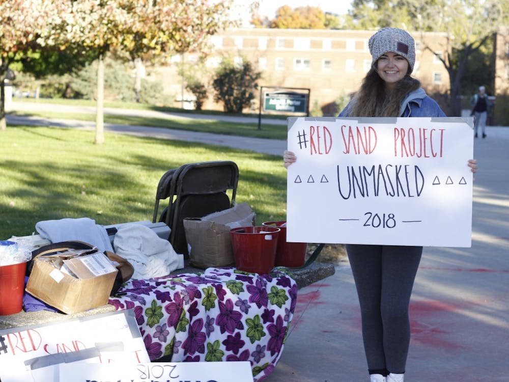 Cosette Hood, a member of Eastern Michigan University's student organization Unmasked, stands by the information table for the project.&nbsp;