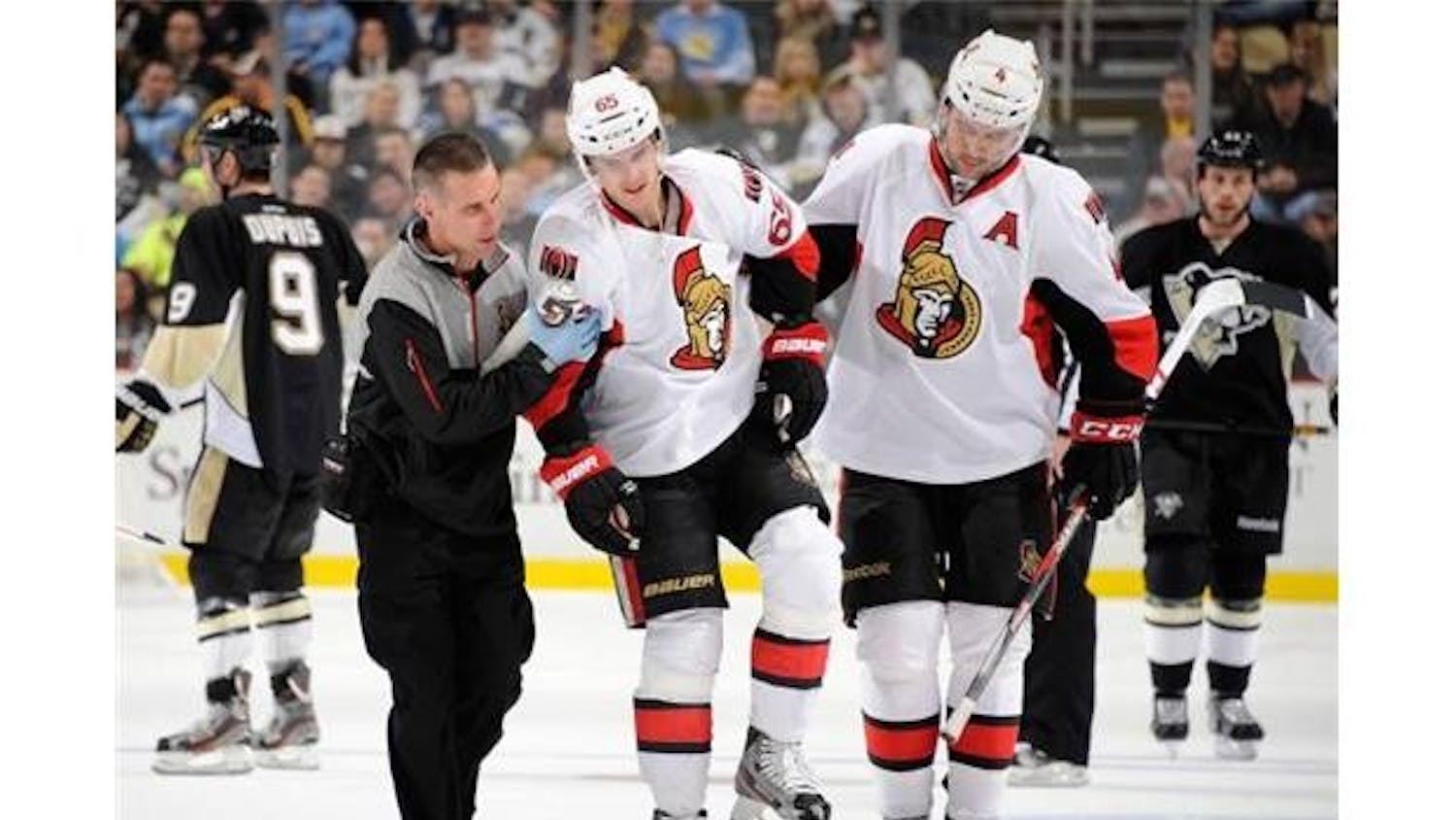 Ottawa’s Erik Karlsson is helped off the ice by Chris Phillips Feb. 13.