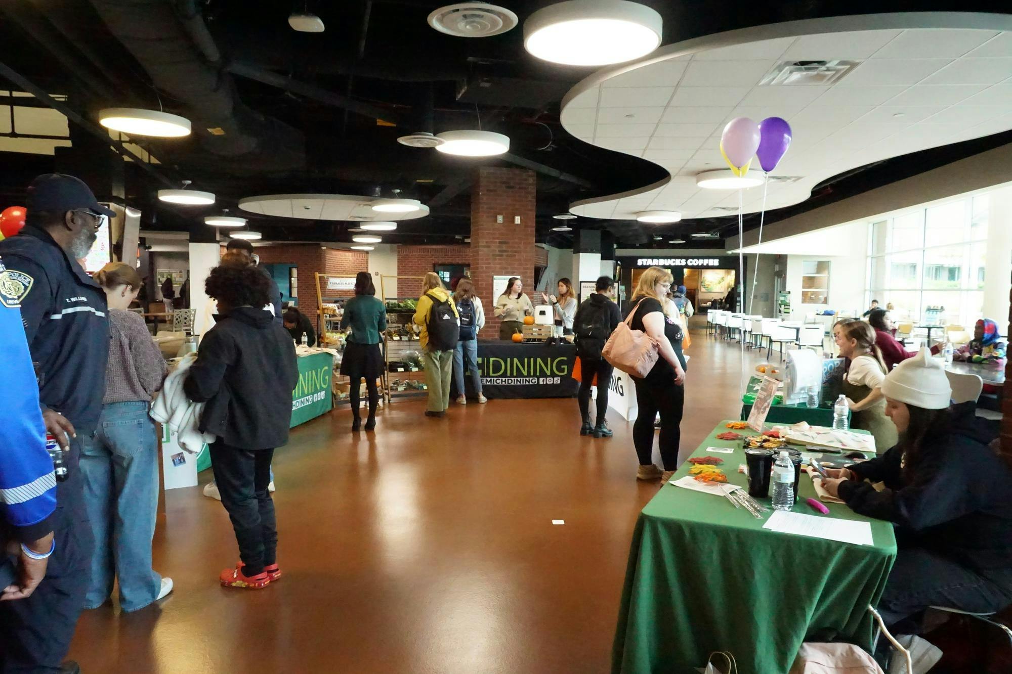 Candid picture of students interacting with the E|dining tables at the event.