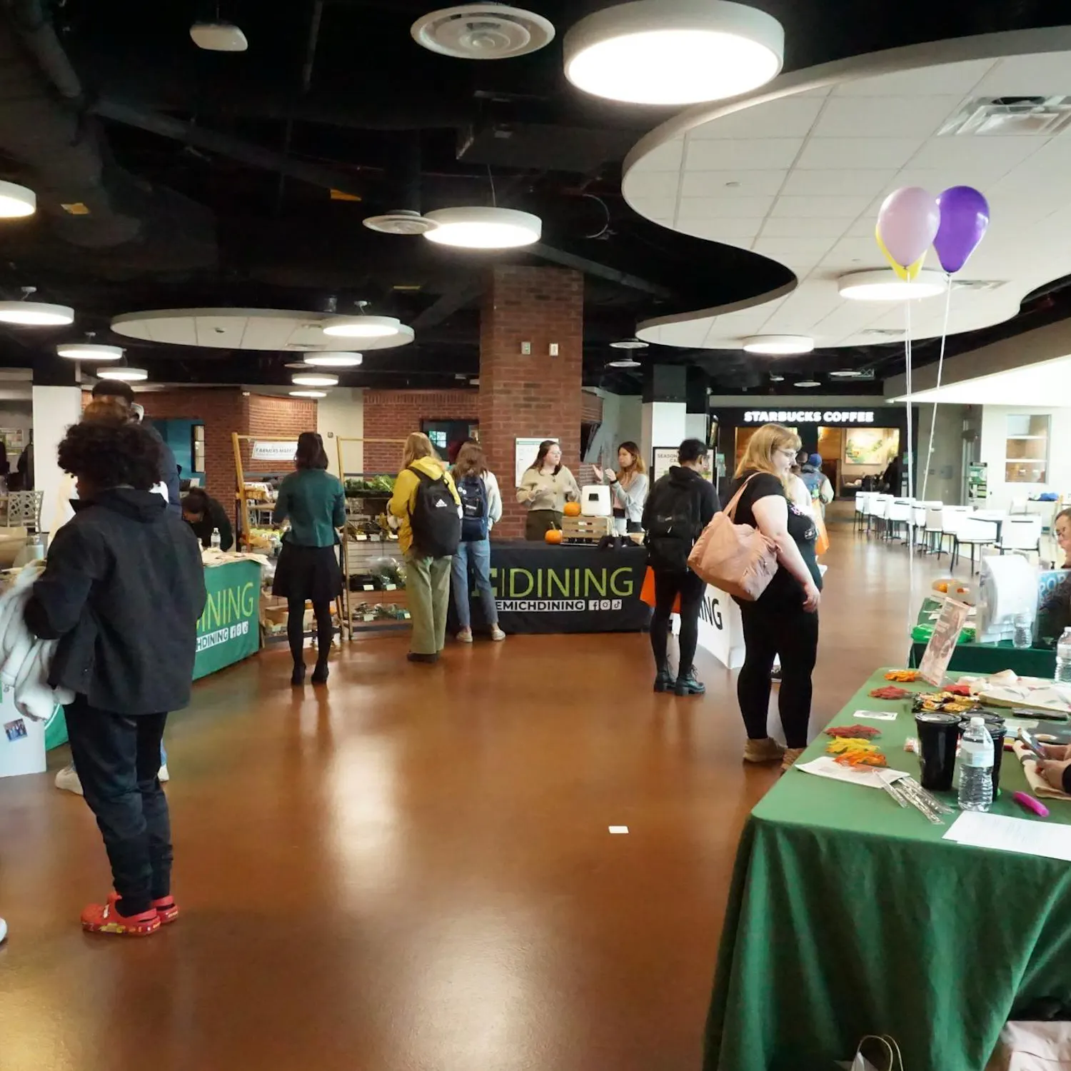Candid picture of students interacting with the E|dining tables at the event.