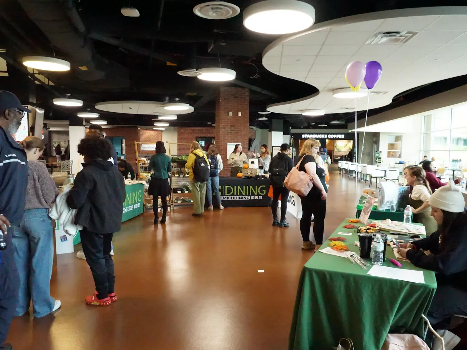 Candid picture of students interacting with the E|dining tables at the event.