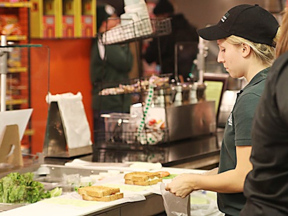 CrossRoads Deli employee Kari Caye prepares one of the shop’s made-to-order sandwiches. The MarketPlace provides a higher end (and higher priced) student dining option.