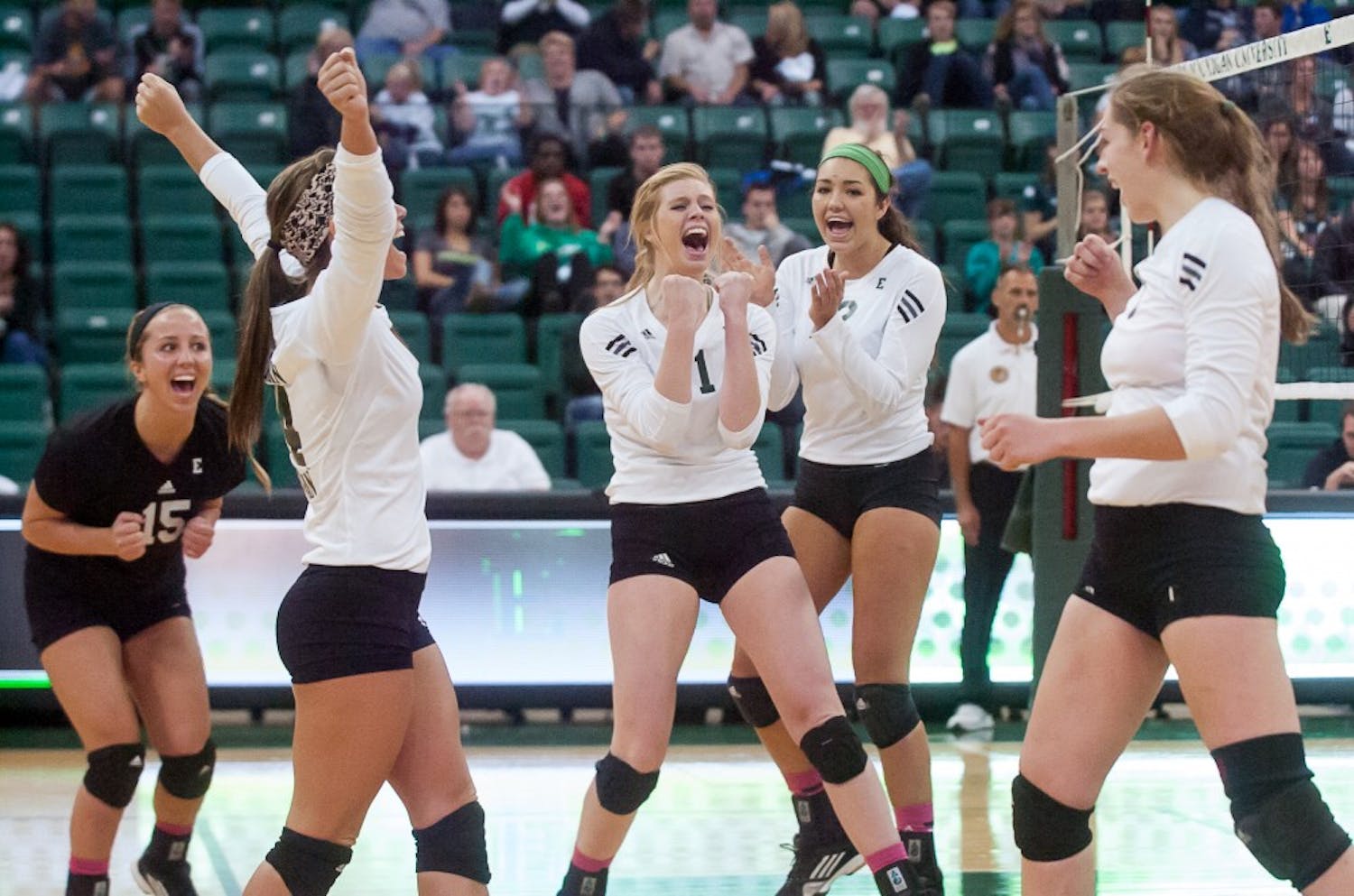 The Eastern Michigan volleyball team celebrates winning a set during the Eagles' loss to Northern Illinois on 10 October at the Convocation Center in Ypsilanti.