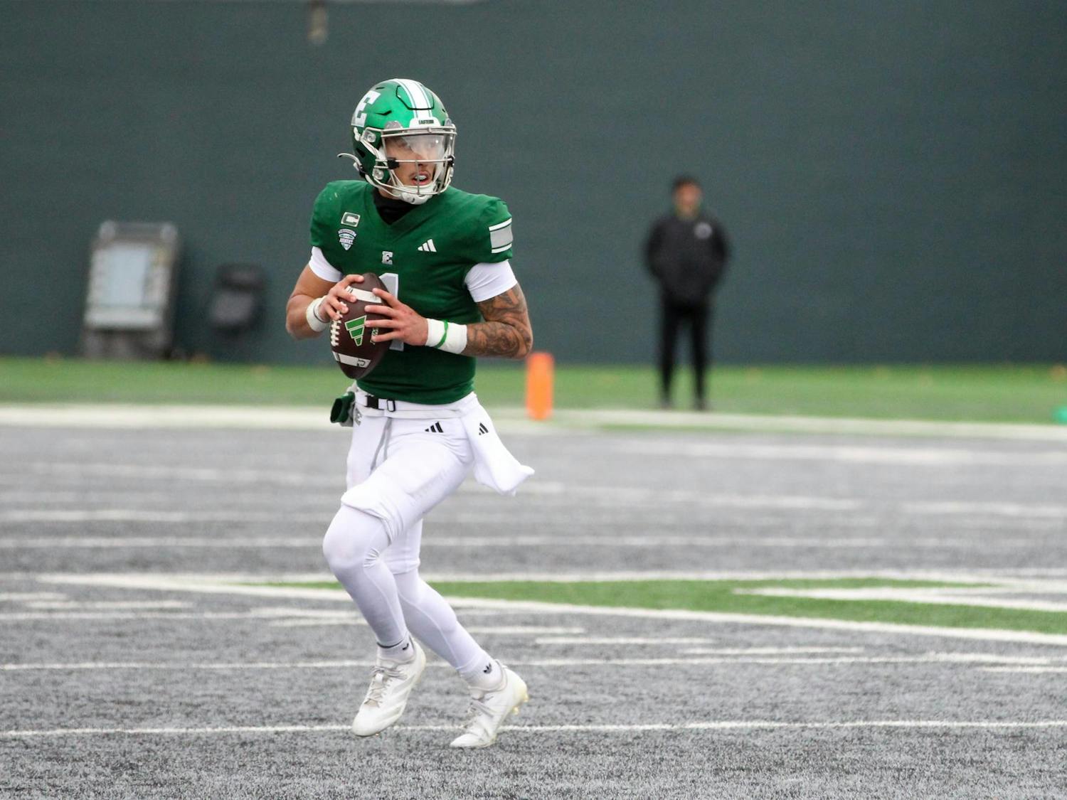 #1, in a green jersey, looks to pass the football