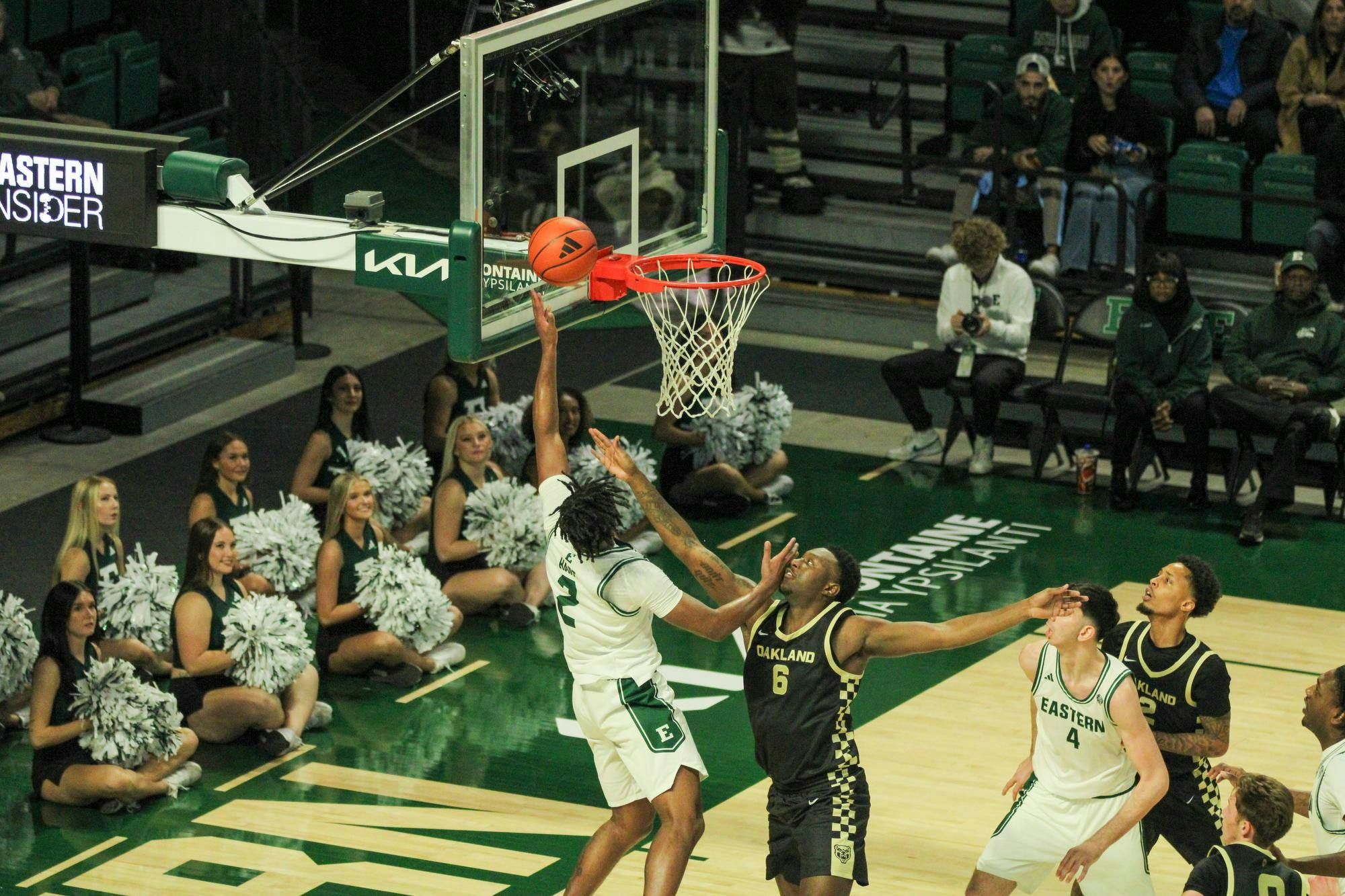#2, in a white jersey, tapping the basketball in