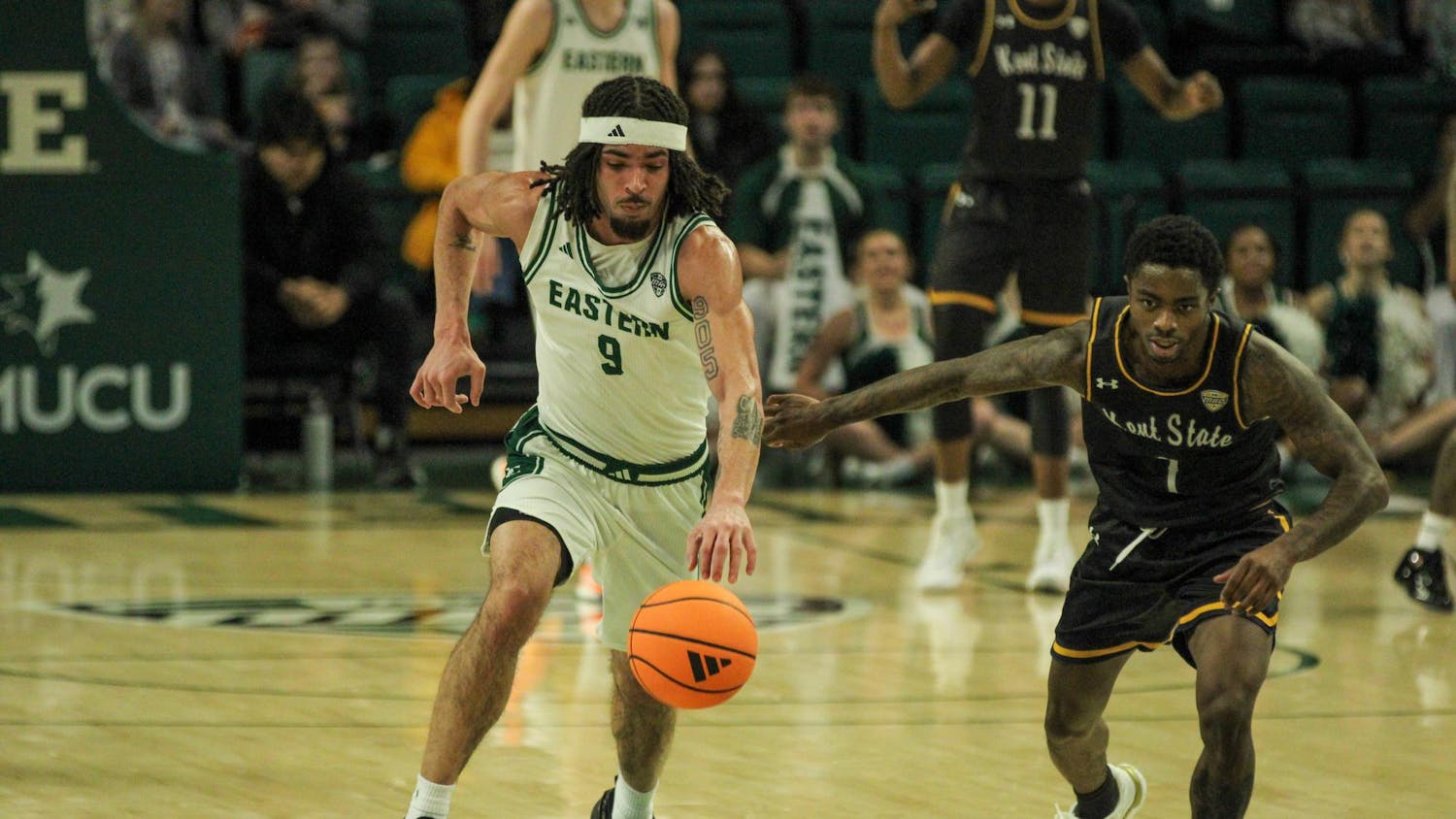 Patterson #9 dribbles the ball while a Kent State player chases him and sticks his arm out.