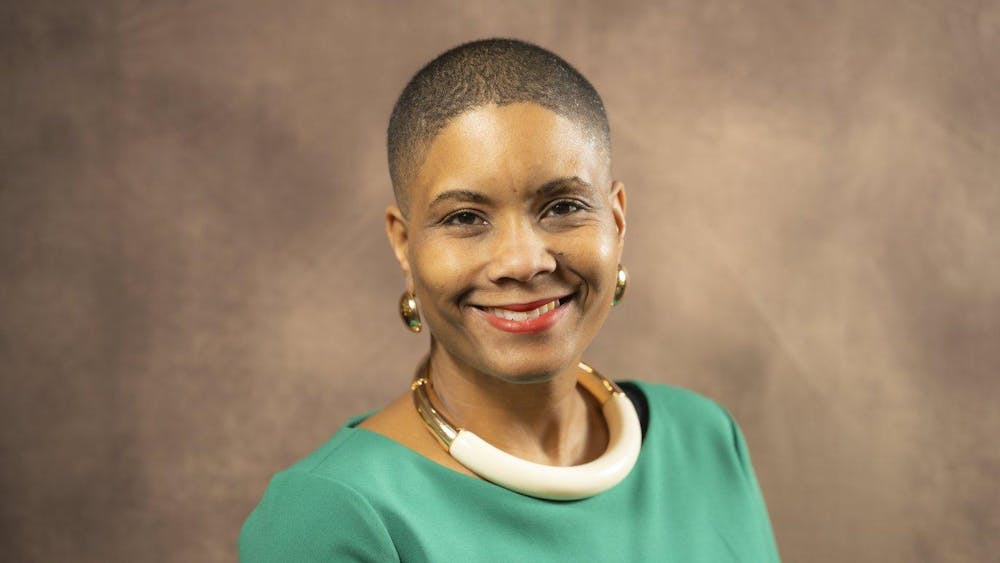 Headshot of Renee' T. Watson from the shoulders up, smiling and wearing a green blouse and gold jewelry.