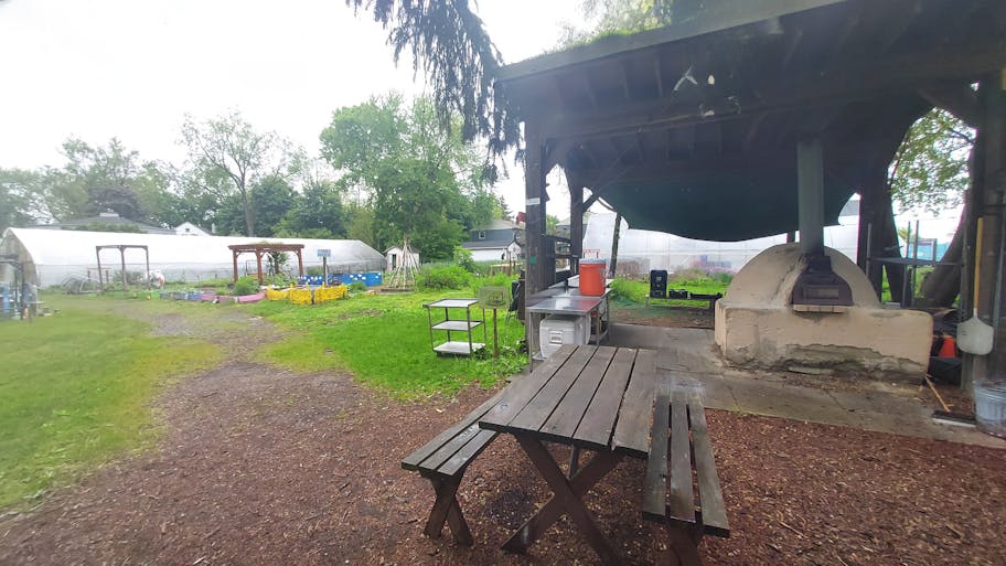A pizza oven is located in the farm’s backyard.