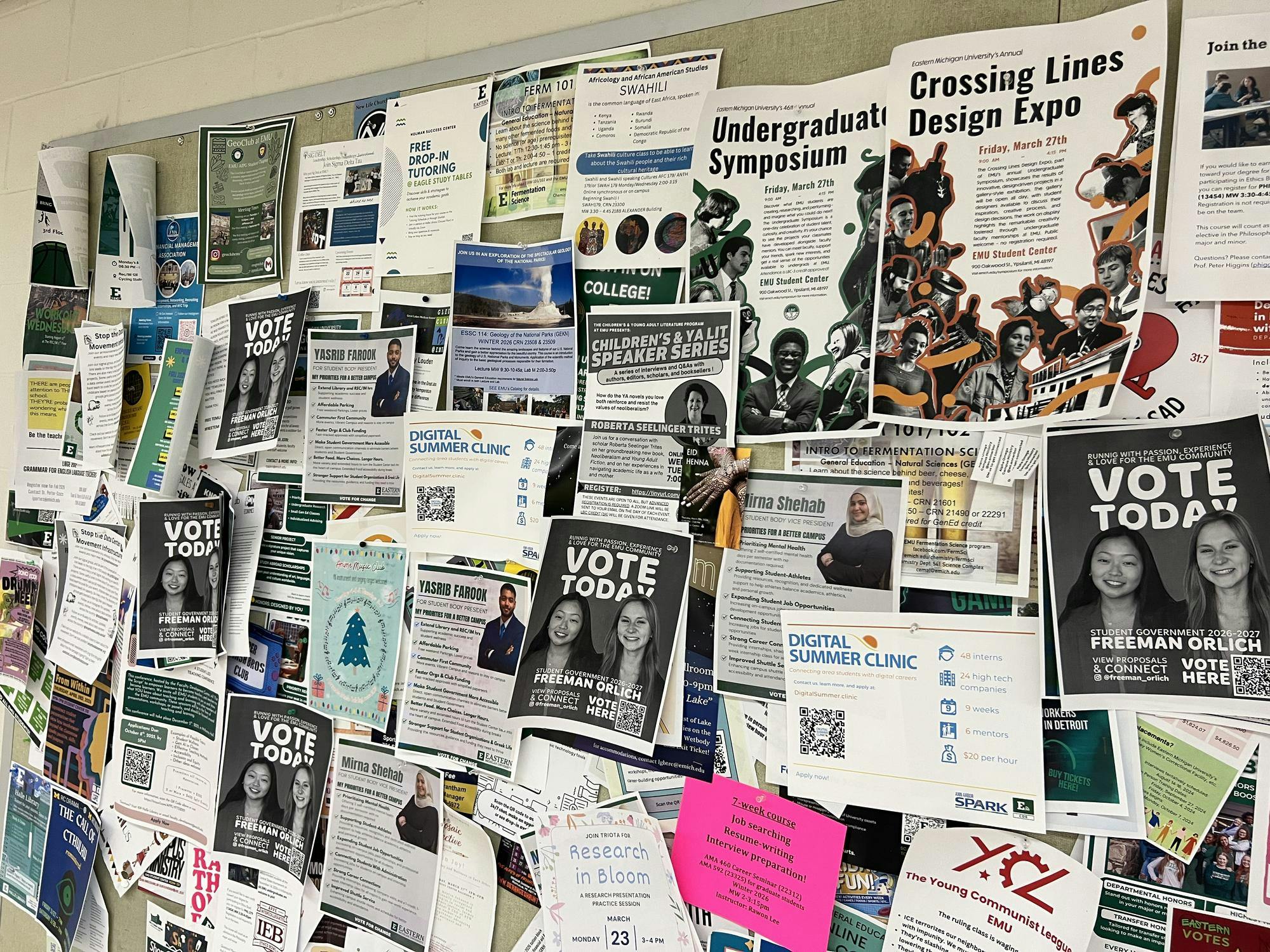 Dozens of flyers, including many campaign flyers, cover a barely visible bulletin board.