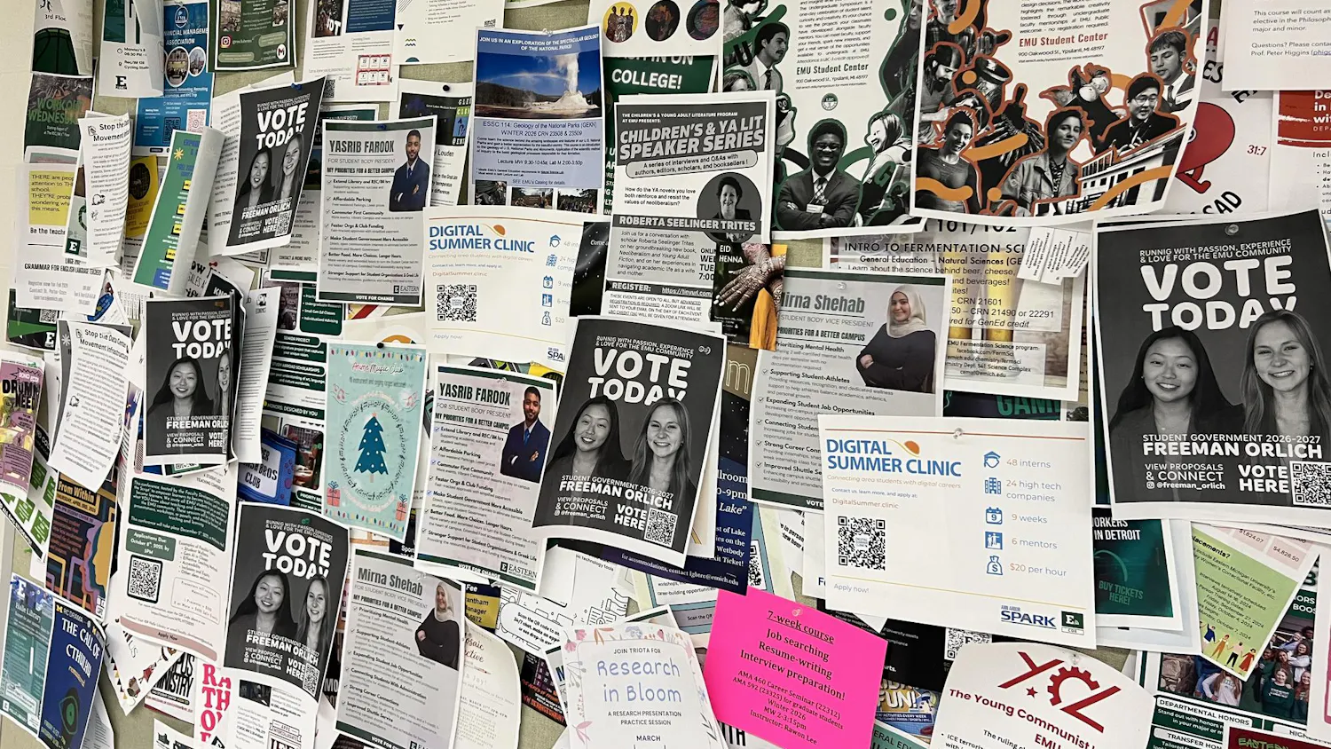 Dozens of flyers, including many campaign flyers, cover a barely visible bulletin board.