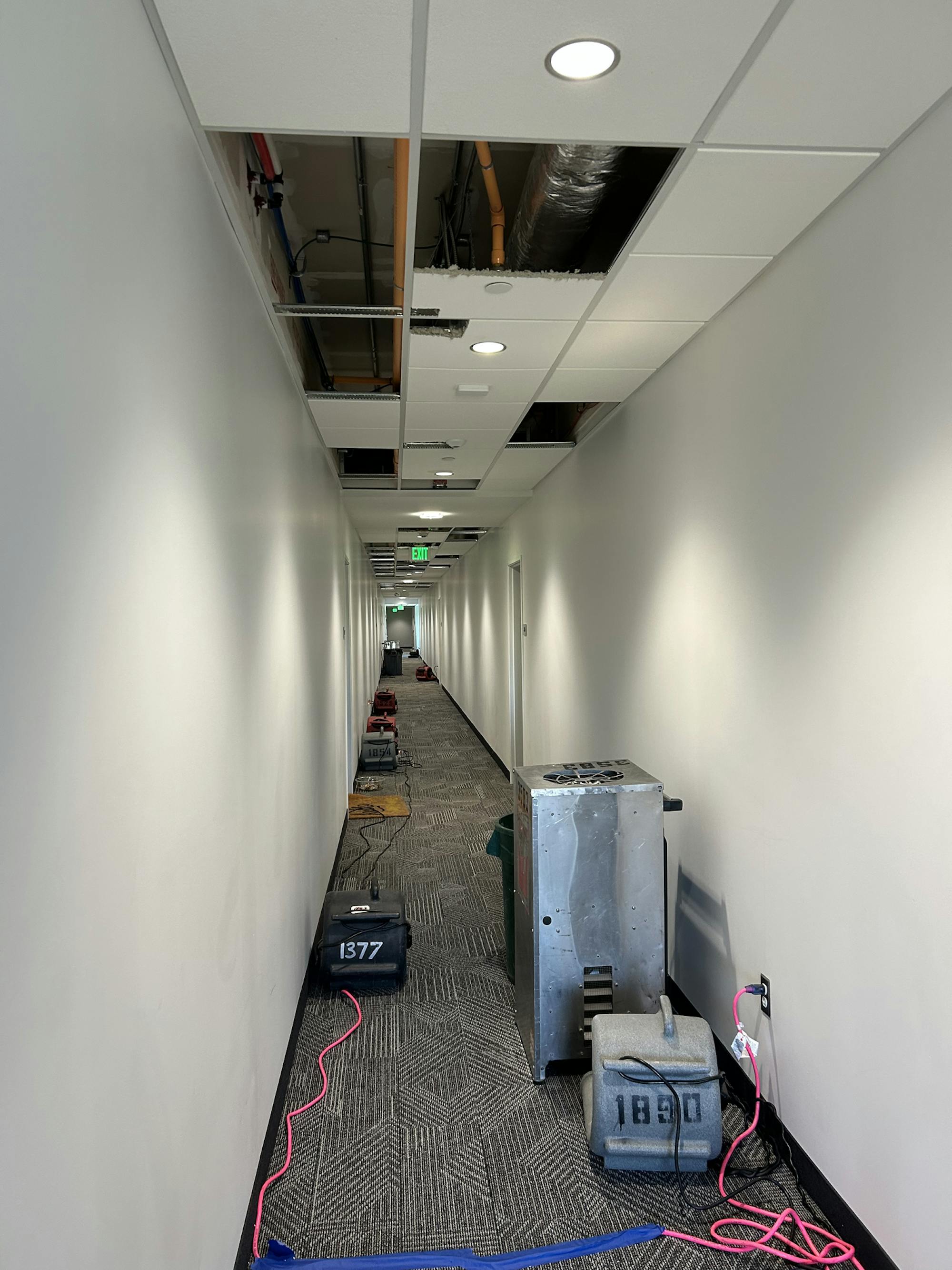 Powerful fans line the floor of a carpeted hallway with white walls after a fire occurred in the Westview Apartments on EMU's campus.