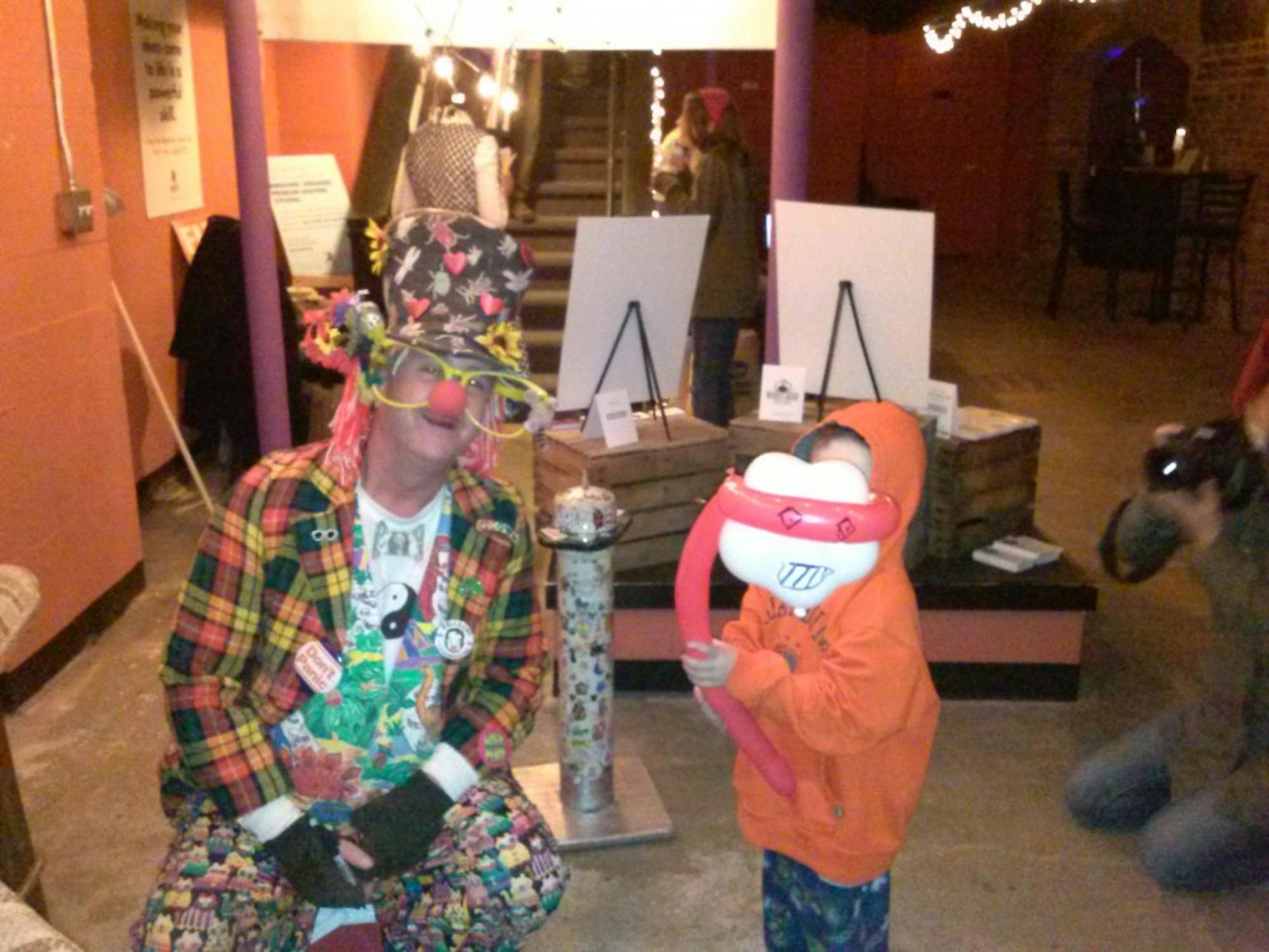 	The colorful Shivy the Clown ties together a balloon critter for a pint-sized attendee.