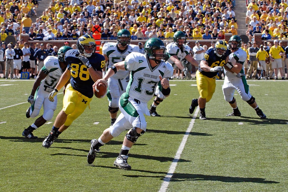 	Alex Gillett (13) under pressure from linebacker (88) Craig Roh during EMU’s 45-17 loss to Michigan on Sept. 19 when he filled in for the injured Andy Schmitt. Gillett will share playing time with Kyle McMahon on Saturday, coach Ron English said.