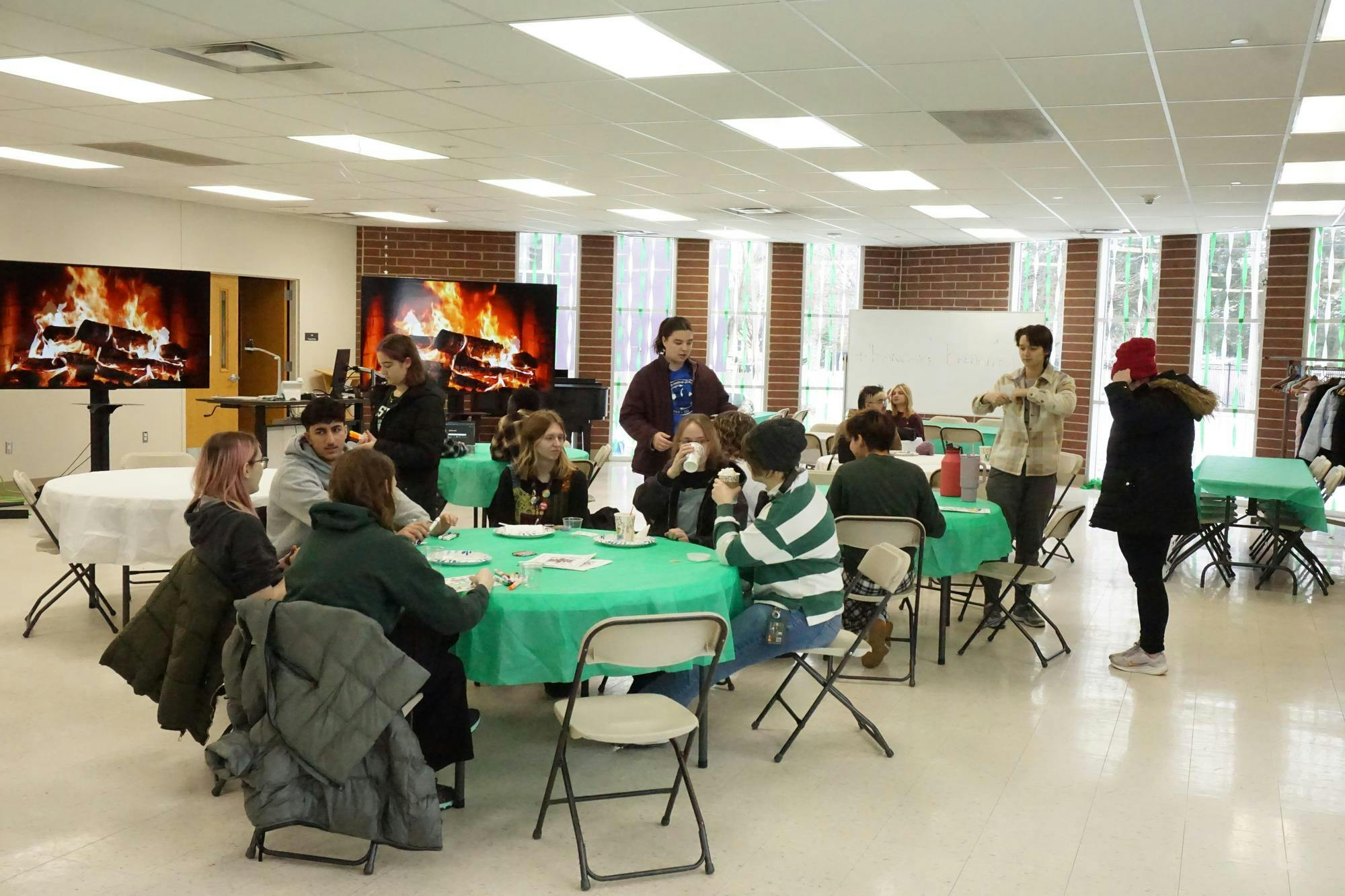 Multiple tables of students converse and color together at the Honors College Pancake Breakfast.