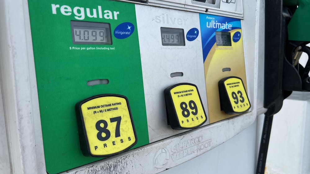 A gas pump shows price per gallon as $4.099 for regular fuel.