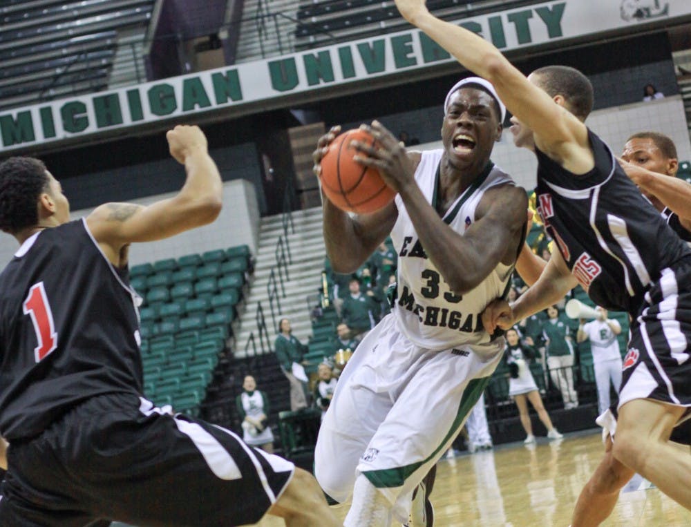 Eagle Brandon Bowdry (above) struggles to get into position to shoot the ball as he is blocked by Nothern Illinois defenders Tuesday night. Despite Bowdry’s two free throws in the last five minutes, EMU lost.