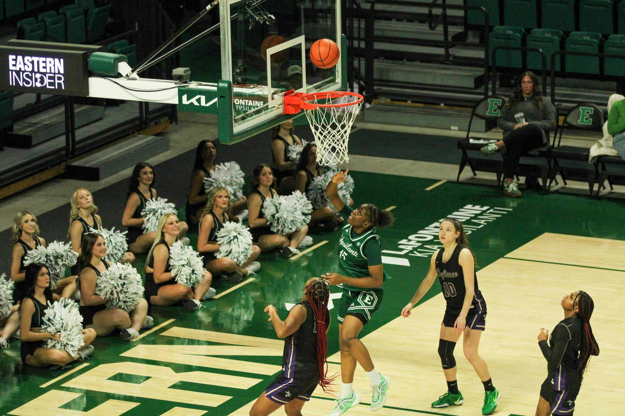 #15 Believe Tshibangu in a green Eastern Michigan University jersey getting a 2-pointer.
