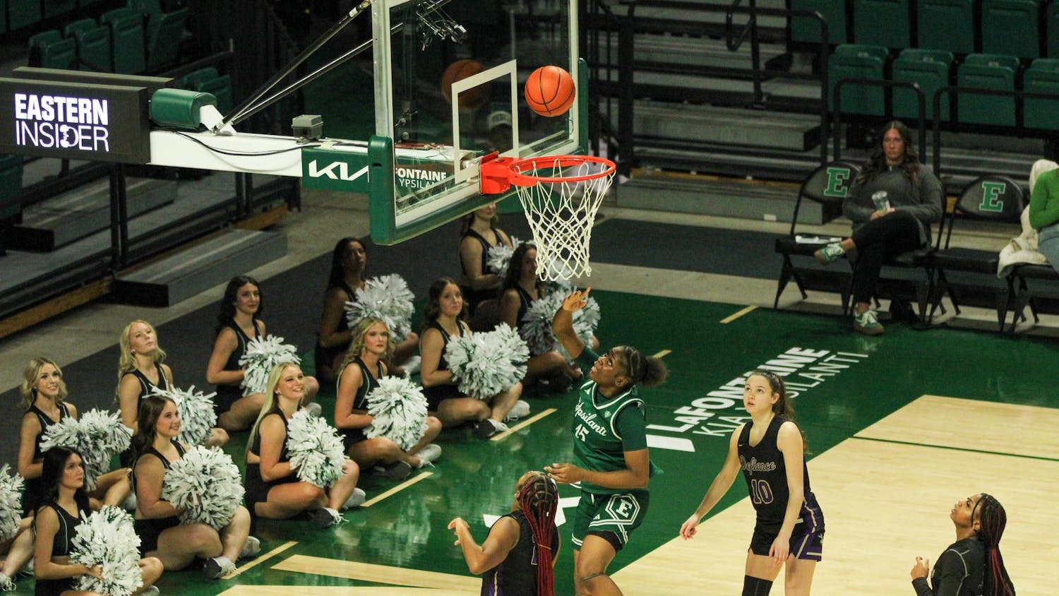 #15 Believe Tshibangu in a green Eastern Michigan University jersey getting a 2-pointer.