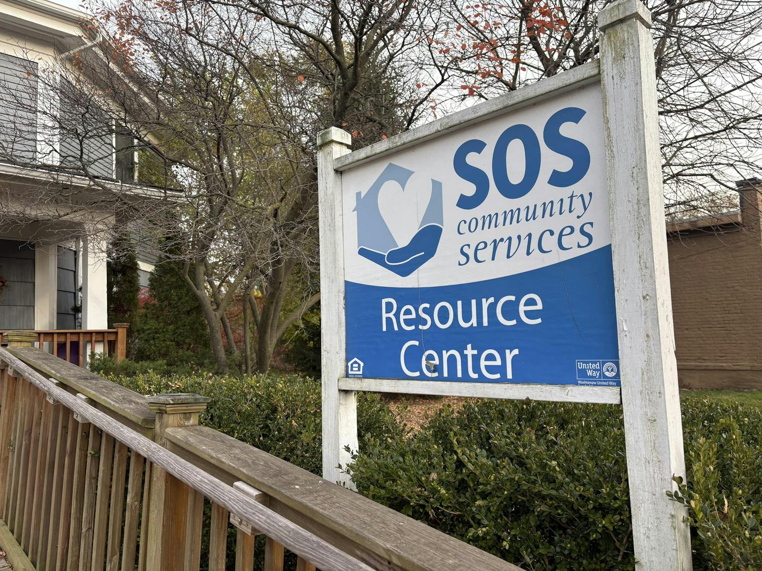 Image of a sign that says "SOS Community Services Resource Center" in white and blue.