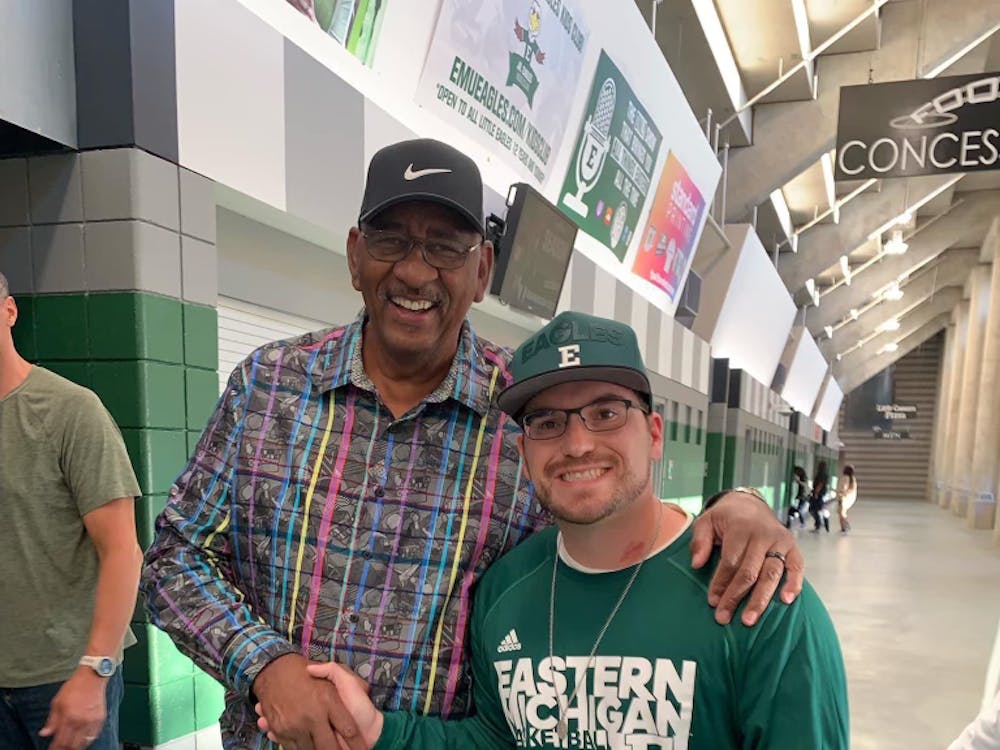 Zack VanNieuwenhze (pictured right), known as 'Vannzee', taking a picture with EMU basketball legend George Gervin (pictured left) inside the George Gervin GameAbove Center.