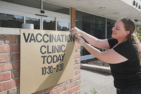 Amanda Lefled, the director of busines opperations at Snow Health Center, is shown here posting a sign with information about move in day vaccination times.