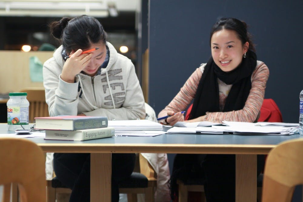 Jingyuan Cao (Left) and Sheila Qin Li get some last-minute studying in before finals week at Halle Library during Club Halle Monday night.