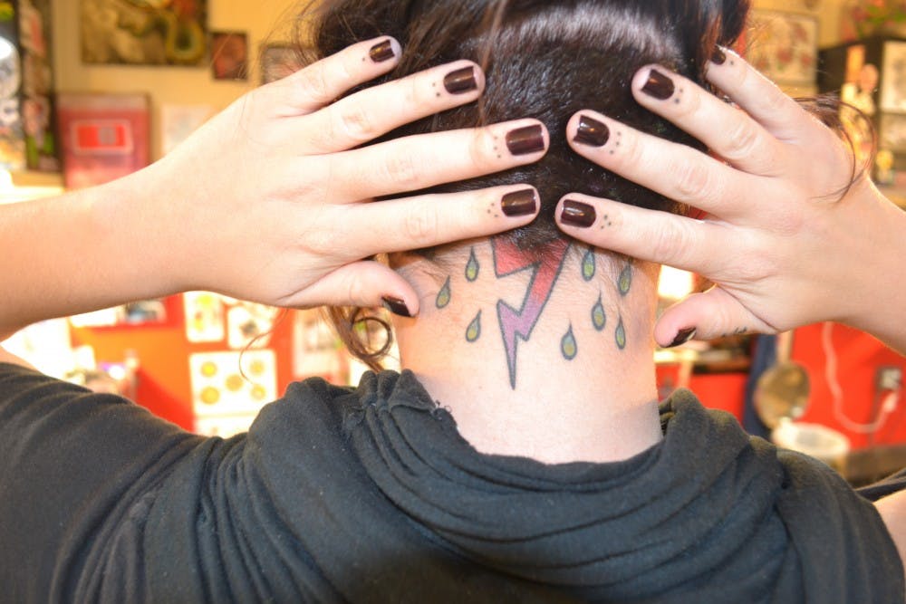 Depot Town Tattoo secretary Alicia Po-picia shows off an electric collection of tattoos.