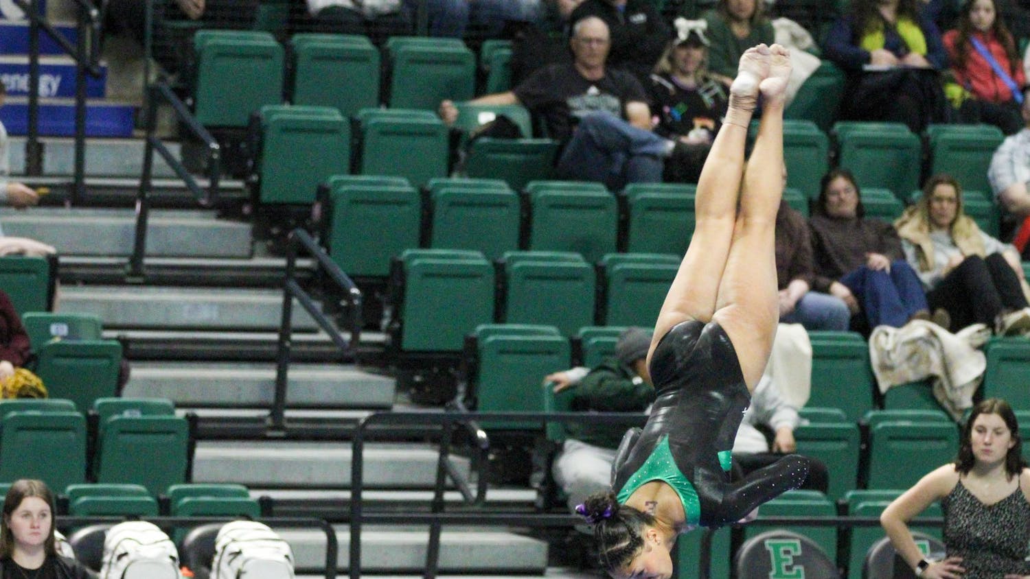 EMU gymnastics player, Kyrie Lowe, upside down in the process of completing a flip.