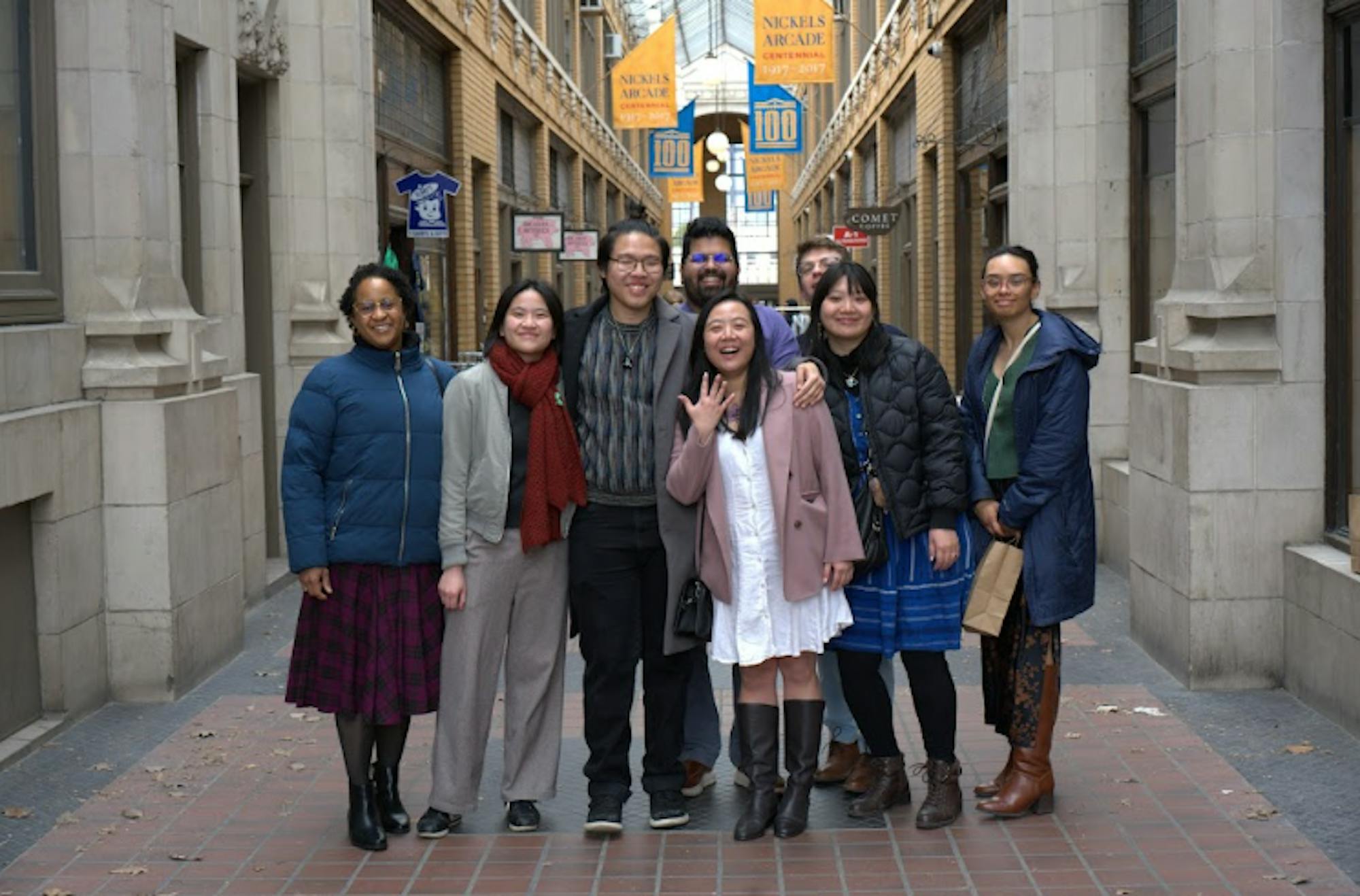Eight people stand in an alleyway located in downtown Ann Arbor, with Christopher Kok and Julian Ho posed in the front. 