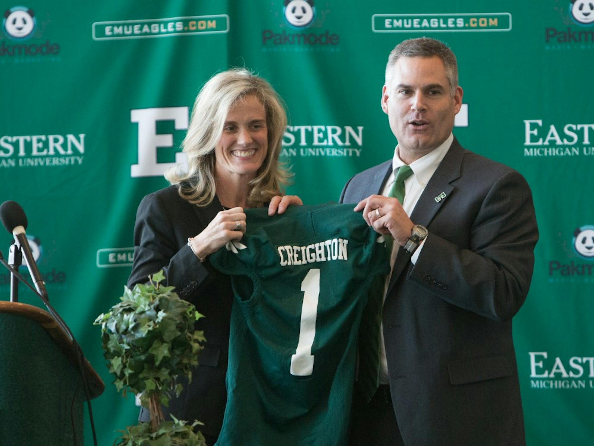 	Heather Lyke, left, and new head football coach Chris Creighton hold up a jersey with his name on it at his introductory press conference as head football coach Thursday afternoon at the Convocation Center.