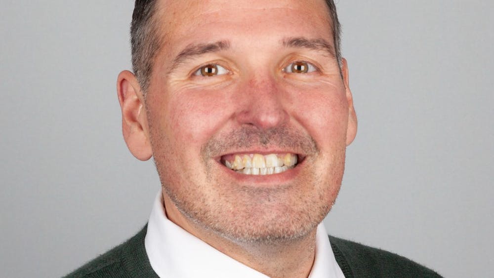Headshot of Matthew Gregory from the shoulders up, wearing a sweater and white collared shirt.
