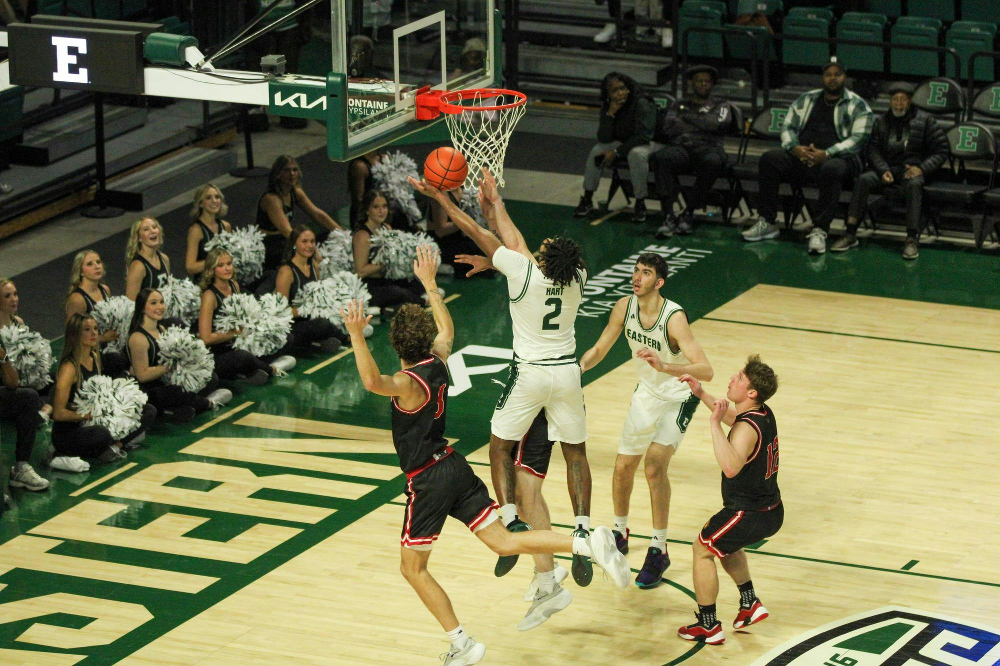 #2, in a white jersey, shooting the ball with IU Indy players, in black jerseys, trying to stop it