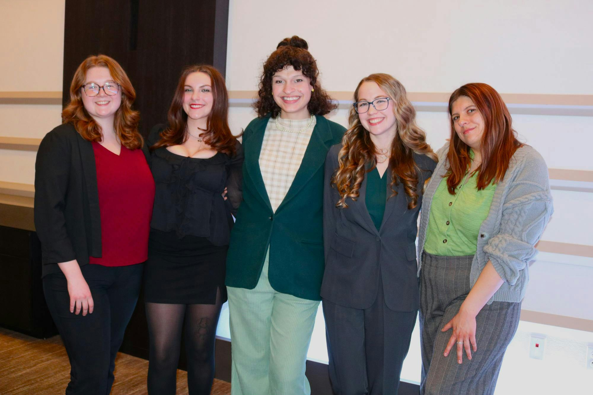 Five students stand and smile at the Michigan Press Association conference.