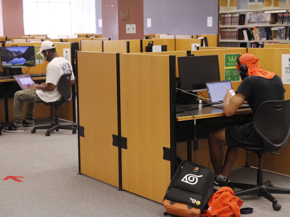 Students use computer stations with face masks on at Eastern Michigan University&#x27;s Halle Library.