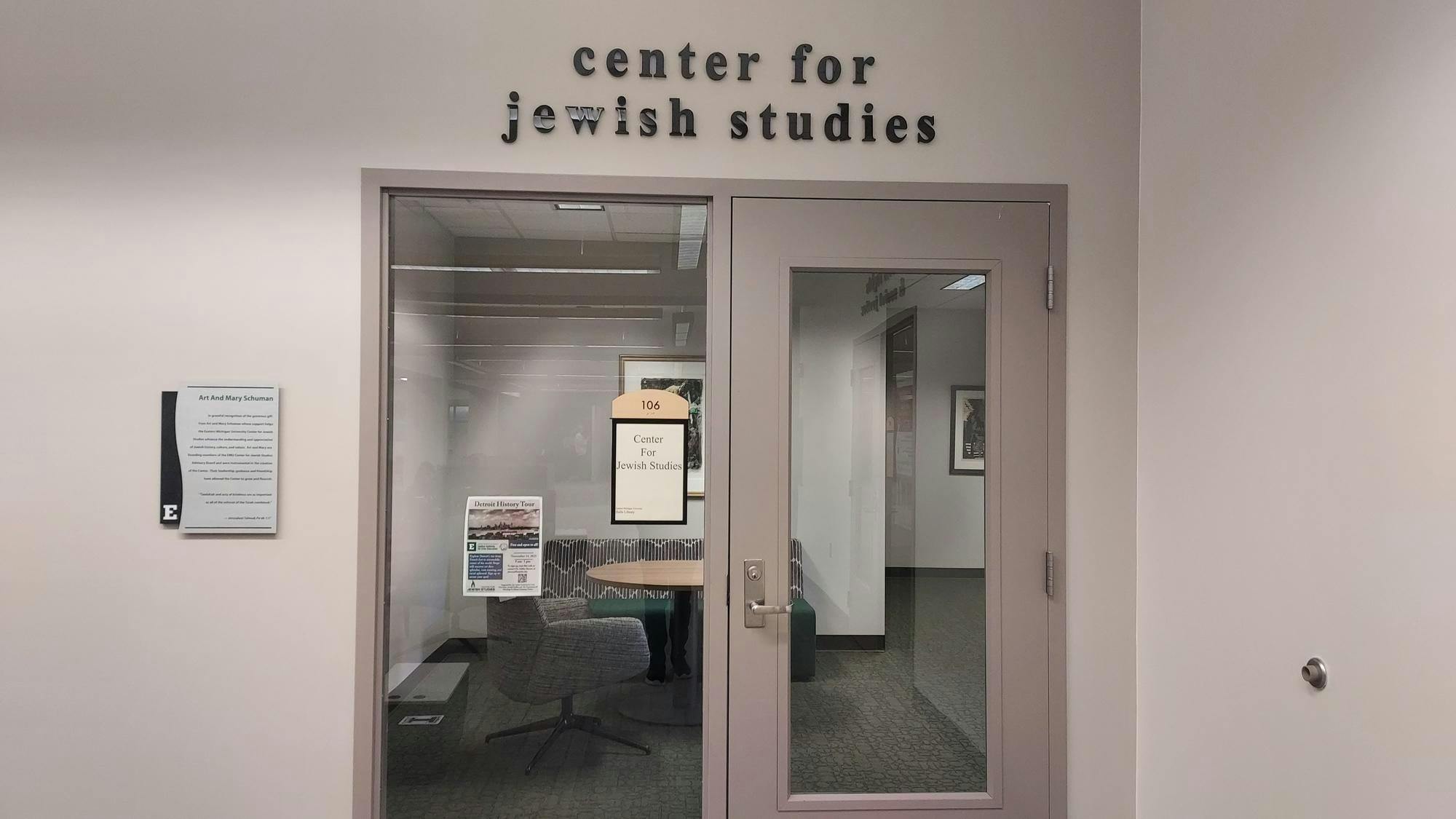 At the entrance to the EMU Center for Jewish Studies, there is a glass door that reflects the interior of the center, and letters outline the name above the door.