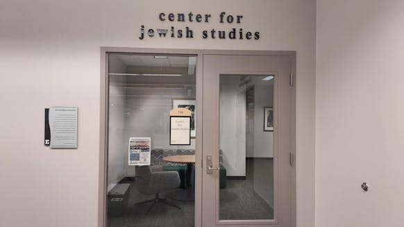 At the entrance to the EMU Center for Jewish Studies, there is a glass door that reflects the interior of the center, and letters outline the name above the door.